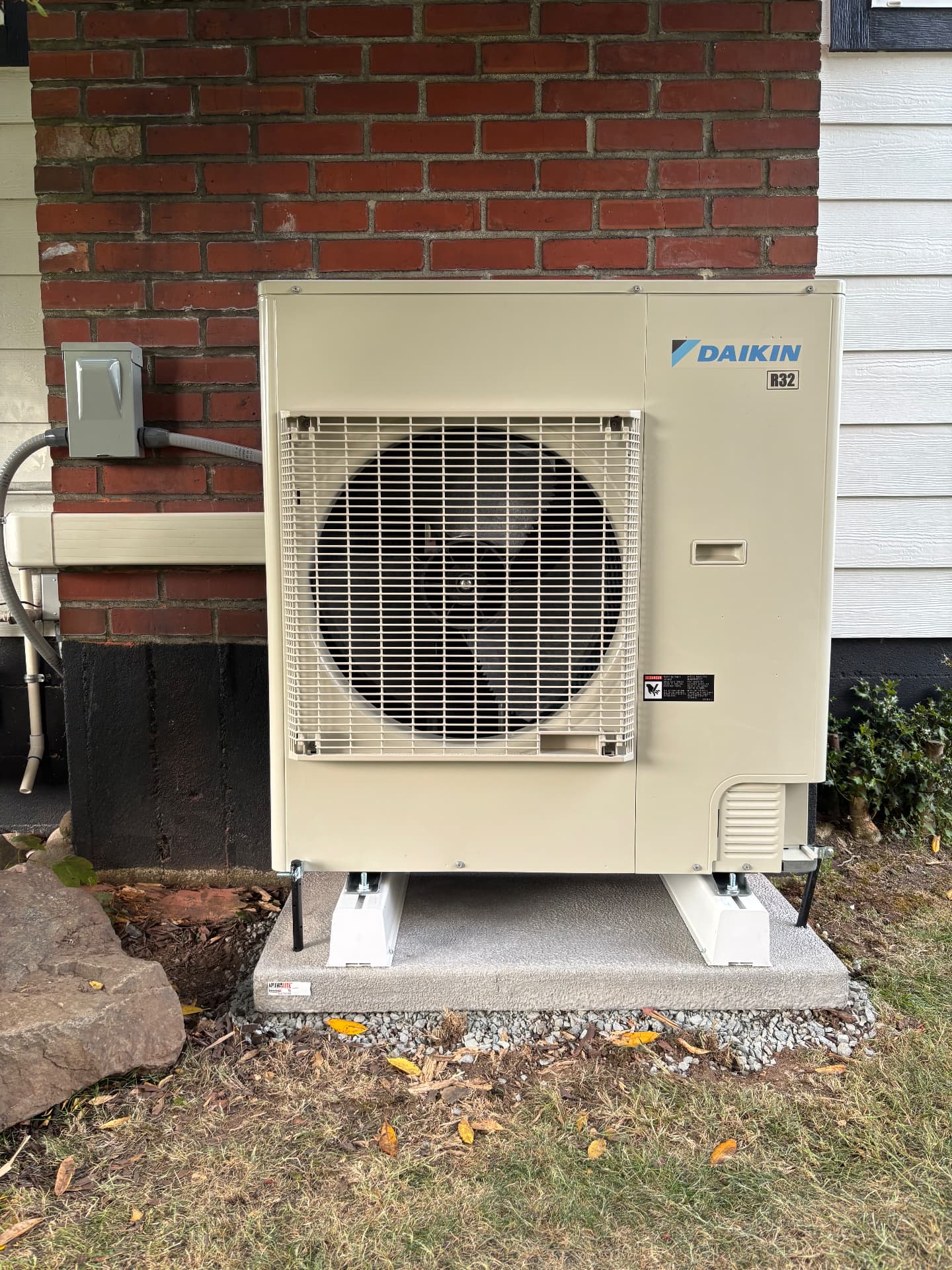 Daikin outdoor unit installed beside a brick home